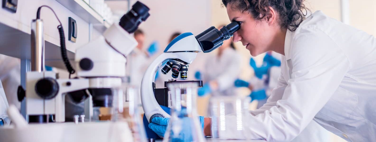 women scientist working on microscope
