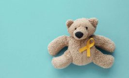 brown teddy bear with gold cancer awareness ribbon