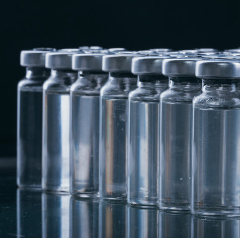 Glass medical ampoule vial for injection. Medicine is dry white drug penicillin powder or liquid with of aqueous solution in ampulla. Close up.